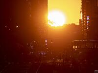 The sun sets along 42nd Street, during the so called "Manhattanhenge", on July 13, 2020 in New York City. The so called Manhattanhenge happens four times each year, when when the sun rises or sets in New York City parallel to the city street grid in Manhattan. Johannes EISELE / AFP