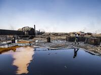 A man walks at a makeshift refinery using burners to distill crude oil in the village of Bishiriya in the countryside near the town of Qahtaniya west of Rumaylan (Rmeilan) in Syria's Kurdish-controlled northeastern Hasakeh province, on July 19, 2020. DELIL SOULEIMAN / AFP