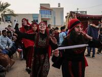 Palestinian girls dressed in traditional clothing dance during an event celebrating their culture in Khan Yunis, in the southern Gaza Strip. (AFP)