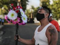 A Catholic faithful wears a face mask as a preventive measure against the spread of the novel coronavirus, COVID-19, during the opening of the ten-day celebration of the Santo Domingo de Guzman festival, outside the Las Sierritas de Santo Domingo church in Managua, on August 1, 2020. Despite the Catholic Church cancelling all religious activities due to the coronavirus pandemic, devotees gathered outside the church for the celebration.