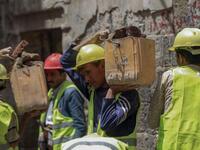 Yemeni labourers remove the rubble ahead of restoration works on the site of a collapsed UNESCO-listed building following heavy rains, in the old city of the Yemeni capital Sanaa, on August 12, 2020. Flash floods triggered by torrential rains have killed at least 172 people across Yemen over the past month, damaging homes and UNESCO-listed world heritage sites, officials said. Mohammed HUWAIS / AFP