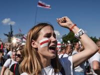 A woman Belarus opposition supporter with a drawing of a former white-red-white flag of Belarus used in opposition to the government punches the air during a demonstration in central Minsk on August 16, 2020. The Belarusian strongman, who has ruled his ex-Soviet country with an iron grip since 1994, is under increasing pressure from the streets and abroad over his claim to have won re-election on August 9, with 80 percent of the vote. Sergei GAPON / AFP