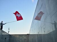 A man waves a flag during a rally of opposition supporters to protest against disputed presidential elections results in Minsk on August 24, 2020. Sergei GAPON / AFP