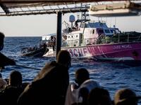 Migrants rescued by Sea-Watch 4 a week ago in the international waters off Libya watch crew members of civil sea rescue ship Sea-Watch 4 on inflatable boats help migrants to get off the rescue ship (AFP)