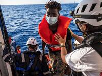 The Louise Michel last night remained dangerously overloaded and was said to be 'losing its balance' but other rescue ships have started to help get migrants off the boat (AFP)