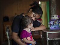 This picture taken on February 9, 2019 shows Nurlina, 19, who got married in 2017, holding her daughter in the village of Galung Lombok in West Sulawesi. Child marriage has long been common in traditional communities from the Indonesian archipelago to India, Pakistan and Vietnam, but numbers had been decreasing as charities made inroads by encouraging access to education and women's health services. YUSUF WAHIL / AFP