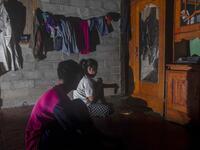 This picture taken on July 22, 2020 shows Marsuki (L) with his underage wife Imani (not her real name) watching television at their parent's house in the village of Pokkang in Mamuju, West Sulawesi. Child marriage has long been common in traditional communities from the Indonesian archipelago to India, Pakistan and Vietnam, but numbers had been decreasing as charities made inroads by encouraging access to education and women's health services. YUSUF WAHIL / AFP