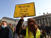 A man holds a placard reading "Tomorrow the sky will be yellow" as protesters wearing protectice face masks gather to take part in a demonstration called by the "yellow vest" (gilets jaunes) movement on September 12, 2020 in Paris. Alain JOCARD / AFP