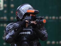 A riot police officer points his gun towards protestors during the fifth straight day of protests against police brutality in Bogota on September 13, 2020. Bogota's Mayor Claudia Lopez, apologized this Sunday for the abuses of the public force, in a ceremony that gathered relatives of the dead and wounded during the bloody protests that broke out five days ago against police brutality in Colombia. DANIEL MUNOZ / AFP