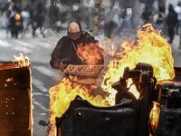 A man stands behind a burning barricade during the fifth straight day of protests against police brutality in Bogota on September 13, 2020. Juan BARRETO / AFP