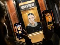 People take a picture of a portrait of Supreme Court Justice Ruth Bader Ginsburg displayed at a storefront on September 19, 2020 in New York, New York. Ginsburg has died at age 87 after a battle with pancreatic cancer. Jeenah Moon/Getty Images/AFP Jeenah Moon / GETTY IMAGES NORTH AMERICA / Getty Images via AFP