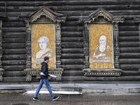 A man walks past a traditional wooden house in the Siberian city of Tomsk on September 8, 2020. Tomsk is considered to be one of the oldest towns in Siberia founded in 1604. Wooden architecture is one of the symbols of the city of Tomsk, its distinctive feature. Today Tomsk is the only city in Siberia where the background wooden buildings have been preserved, reflecting the manor structure of the city streets. Unfortunately, many wooden houses are not in very good condition and require restoration. Alexande