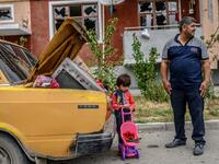 A man stands with his kid by a car outside a damaged apartment building after the family took their last belongings from their flat during a ceasefire during a military conflict between Armenia and Azerbaijan over the breakaway region of Nagorno-Karabakh, in the town of Terter, Azerbaijan, on October 10, 2020. Armenia and Azerbaijan traded accusations of new attacks on October 10 in breach of a ceasefire deal to end nearly two weeks of heavy fighting over the disputed Nagorno-Karabakh region. Bulent Kilic /