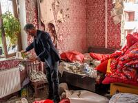Yasin Budakov, 40, holds a book which his kid forgot to take when they were running out of his damaged flat as residents return to their homes following a ceasefire during a military conflict between Armenia and Azerbaijan over the breakaway region of Nagorno-Karabakh, in the town of Terter, Azerbaijan, on October 10, 2020. Armenia and Azerbaijan traded accusations of new attacks on October 10 in breach of a ceasefire deal to end nearly two weeks of heavy fighting over the disputed Nagorno-Karabakh region. 