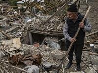 Retired police officer Genadiy Avanesyan, 73, searches for belongings in the remains of his house, which is said was destroyed by Azeri shelling, in the city of Stepanakert on October 10, 2020. Amenia and Azerbaijan traded accusations of new attacks on October 10 in breach of a ceasefire deal to halt nearly two weeks of fierce fighting over the disputed Nagorno-Karabakh region. ARIS MESSINIS / AFP