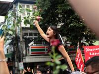 A pro-democracy protester holds up flowers while shouting slogans during an anti-government rally in Bangkok on October 14, 2020. Jack TAYLOR / AFP