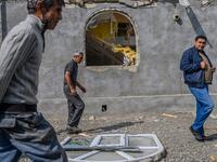 Men pass in front of a house destroyed by shellings in the village of Bakharly, near Agdam city during the ongoing fighting between Armenia and Azerbaijan over the disputed region, in the city of Terter on October 14, 2020. Azerbaijan said on October 14, 2020 it had destroyed missile launchers inside Armenia that were targetting its cities, as fierce fighting over Nagorno-Karabakh risked widening beyond the disputed region. Hundreds have already lost their lives in two weeks of fighting, and continued clash