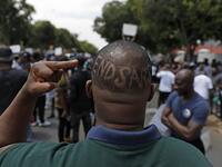 A Nigerian based in South Africa shows the middle finger and words "EndSars" shaved on his head during a protest outside the Nigerian embassy in Pretoria on October 21, 2020 in solidarity with Nigerian youth who are demanding an end to police brutality in the form of The Nigerian Police Force Unit, Special Anti-Robbery Squad (SARS). Phill Magakoe / AFP