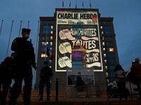 Police officers stand guard as cartoons of French satirical weekly newspaper Charlie Hebdo are projected onto the facade of the Hotel de Region in Montpellier, on October 21, 2020, during a national homage to French teacher Samuel Paty who was beheaded for showing cartoons of the Prophet Mohamed in his civics class. Pascal GUYOT / AFP