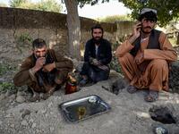 In this photo taken on September 27, 2020, labourers take a rest as they drink tea at Deh Qubad village in Maiwand district of Kandahar province. The dry and dusty village of Aziz Abad in Maiwand district sits on the frontline of Afghanistan's war and is currently under government control -- but only just. WAKIL KOHSAR / AFP