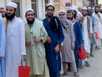 In this picture taken on October 19, 2020 Islamic seminary students wait to collect food at the Darul Uloom Haqqania seminary in Akora Khattak. The Darul Uloom Haqqania seminary has churned out a who's who of Taliban top brass -- including many now on the hardline group's negotiating team holding talks with the Kabul government to end a 20-year war. Abdul MAJEED / AFP