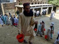 In this picture taken on October 19, 2020 Islamic seminary students wait to collect food at the Darul Uloom Haqqania seminary in Akora Khattak. The Darul Uloom Haqqania seminary has churned out a who's who of Taliban top brass -- including many now on the hardline group's negotiating team holding talks with the Kabul government to end a 20-year war. Abdul MAJEED / AFP