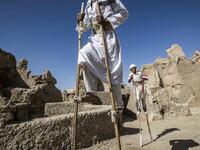 Egyptian school children dressed in traditional outfits, walk with stilts during a celebration to mark the inauguration of the fortress of Shali following its restoration, in the Egyptian desert oasis of Siwa, some 600 kms southwest of the capital Cairo, on November 6, 2020. Khaled DESOUKI / AFP