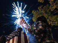 Supporters of US President-elect Joe Biden watch fireworks as they celebrate near the White House on November 7, 2020 in Washington, D.C. Democrat Joe Biden urged unity on November 7 and promised "a new day for America" in his first national address since he won the tense US election and ended the historically turbulent and divisive era of Donald Trump. Alex Edelman / AFP