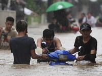 Residents carry their belongings as they make their way through a flooded street to shelter after Typhoon Vamco hit, in Marikina City, suburban Manila on November 12, 2020. Ted ALJIBE / AFP