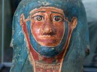 A picture shows a funerary mask on display during the unveiling of an ancient treasure trove of more than a 100 intact sarcophagi, at the Saqqara necropolis 30 kms south of the Egyptian capital Cairo, on November 14, 2020. Egypt announced the discovery of an ancient treasure trove of more than a 100 intact sarcophagi, the largest such find this year. The sealed wooden coffins, unveiled on site amid fanfare, belonged to top officials of the Late Period and the Ptolemaic period of ancient Egypt. They were fou