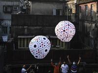 Revellers release handmade sky-lanterns from the terrace of a building to celebrate Diwali, the Hindu festival of lights, in Kolkata on November 14, 2020. Dibyangshu SARKAR / AFP