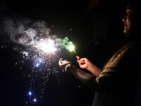 A woman lights sparklers during Diwali, the Hindu Festival of Lights, in Allahabad on November 14, 2020. SANJAY KANOJIA / AFP