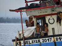 This photo taken on June 25, 2020 shows six-year-old Nosmin Fatima (R) with other Rohingya migrants as they arrive in Lhokseumawe in North Aceh. Weeks after a funeral for the wife and daughter he thought had died at sea while trying to sail to him, Nemah Shah was stunned when he saw online images of them emerging from a refugee boat in Indonesia.  CHAIDEER MAHYUDDIN / AFP