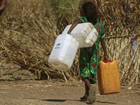 An Ethiopian refugee girl walks carrying water containers at Um Raquba camp in Sudan's eastern Gedaref province on November 28, 2020. Sudan needs $150 million in aid to cope with the flood of Ethiopian refugees crossing its border from conflict-stricken Tigray, the UN refugee agency chief said during a visit to a camp. ASHRAF SHAZLY / AFP