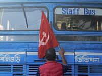 An activist of Communist Party of India (Marxist) (CPI-M) stops a bus as he blocks a road during a rally to support nationwide general strike called by farmers to protest against the recent agricultural reforms in Siliguri on December 8, 2020. Diptendu DUTTA / AFP