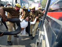 Policemen detain a student leader during a protest in support of the nationwide general strike called by farmers against the recent agricultural reforms in Allahabad on December 8, 2020. SANJAY KANOJIA / AFP