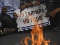 Congress activists hold placards next to a burning an effigy of Prime Minister Narendra Modi while blocking a road during a protest in support of the nationwide general strike called by farmers against the recent agricultural reforms in Kolkata on December 8, 2020. Dibyangshu SARKAR / AFP