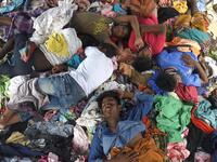 This file picture taken on September 8, 2020 shows a group of Rohingya men sleeping on a pile of donated clothes at a transit camp after nearly 300 Rohingya migrants came ashore on the beach in Lhokseumawe on the northern coast of Indonesia's Sumatra island. Boatloads of Rohingya landing across Southeast Asia are victims of complex human trafficking networks run by a dizzying web of players, from crime bosses and corrupt cops to poor fishermen, rickshaw drivers and even Rohingya themselves. Rahmat Mirza / A