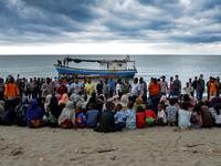 In this file photo taken on June 25, 2020 Rohingya migrants sit by the beach after their boat landed on the shores of Lancok village, in Indonesia's North Aceh Regency. Boatloads of Rohingya landing across Southeast Asia are victims of complex human trafficking networks run by a dizzying web of players, from crime bosses and corrupt cops to poor fishermen, rickshaw drivers and even Rohingya themselves. CHAIDEER MAHYUDDIN / AFP