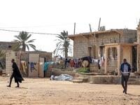 A man walks near a laundry clothing line hanging in the open by a building in the city of Tawergha, some 200 kilometres (125 miles) east of Libya's capital close to the port city of Misrata, on December 12, 2020. When Libyan dictator Moamer Kadhafi was toppled, people took revenge on those they saw as his supporters -- including the entire town of Tawergha, whose 40,000 residents were forced to flee. Now, almost a decade later since militia forces rampaged through the town torching homes, destroying buildin