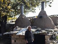 Syrian-Armenian potter Misak Antranik Petros walks outside his workshop located inside an ancient mud-brick house near the city of Qamishli in Syria's northeastern Hasakeh province, on December 19, 2020. Petros was only a teenager when he had to take over for his sick father and become the main potter of the family. He has since become a master of the craft, and is keen to pass his skills on.  Delil SOULEIMAN / AFP