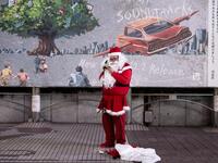 A lone performer dressed as Santa Claus prepares for his performance on Christmas eve, in Shibuya district of Tokyo on December 24, 2020. Philip FONG / AFP
