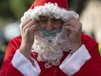 A swimmer in a Santa Claus costume prepares to participate in the 111th edition of the Copa Nadal (Christmas Cup) swimming race in Barcelona's Port Vell on December 25, 2020. The traditional 200-meter Christmas swimming race gathered around 300 participants on Barcelona's Port Vell (old harbour). Josep LAGO / AFP