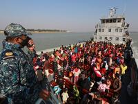 Rohingya refugees sit on a Bangladesh Navy ship as they are relocated to the controversial flood-prone island Bhashan Char in the Bay of Bengal, in Chittagong on December 29, 2020. Rehman ASAD / AFP