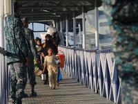Rohingya refugees embark on a Bangladesh Navy ship as they are relocated to the controversial flood-prone island Bhashan Char in the Bay of Bengal, in Chittagong on December 29, 2020. Rehman ASAD / AFP