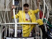 In this file photo taken on July 21, 2020 British designer Vivienne Westwood gestures from inside a giant bird-cage, suspended off the ground, in front Of the Old Bailey in central London on July 21, 2020, in protest of the extradition trial of Wikileaks founder Julian Assange. The legal controversies surrounding the WikiLeaks founder Julian Assange are now in their second decade and the divisions between his supporters and critics remain as intractable as ever. Niklas HALLE'N / AFP