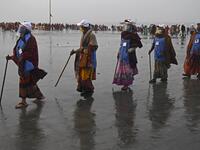 Members of local village panchayat wearing face shields and masks inspect the sanitization on the beach as a preventive measure against the Covid-19 coronavirus at the confluence of Ganges and the Bay of Bengal during the Gangasagar Mela on the occasion of Makar Sankranti, a day considered to be of great religious significance in Hindu mythology, at Sagar Island, around 150 kms south of Kolkata on January 14, 2021. Dibyangshu SARKAR / AFP