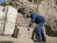 Egyptologist Zahi Hawass examines inscriptions on an unearthed structure during the official announcement of the discovery by an archaeological mission he leads of a new trove of treasures at Egypt's Saqqara necropolis south of Cairo, on January 17, 2021. The discovery at the necropolis which lies 30kms south of the Egyptian capital, includes the funerary temple of Queen Naert, wife of King Teti, as well as burial shafts, coffins, and mummies dating back to nearly 3000 years ago during the New Kingdom. Khal