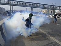 A farmer throws back a tear gas shell towards police during a tractor rally as farmers continue to protest against the central government's recent agricultural reforms in New Delhi on January 26, 2021. Sajjad HUSSAIN / AFP