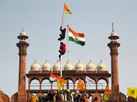 Protesters climb a flagpole at the ramparts of the Red Fort as farmers continue to demonstrate against the central government's recent agricultural reforms in New Delhi on January 26, 2021. Sajjad HUSSAIN / AFP
